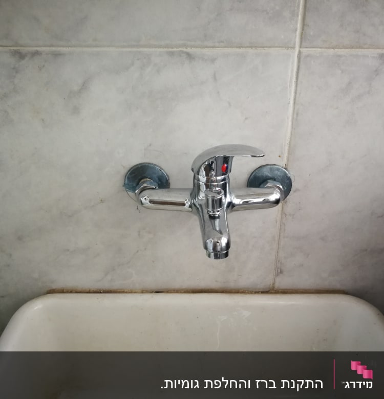 ברז כרום מותקן על קיר מעל כיור לבן